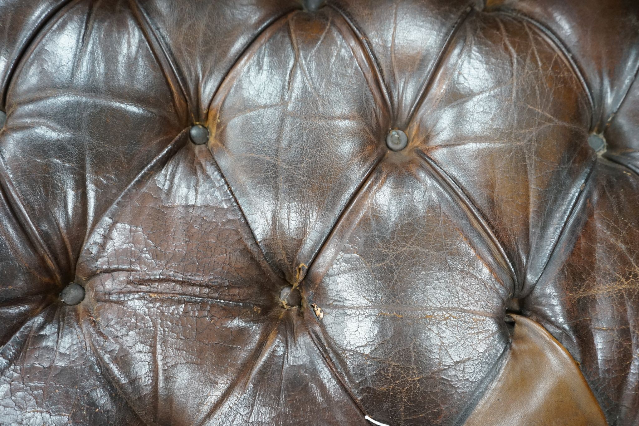 An early 20th century Chesterfield settee upholstered in deep buttoned brown leather, length 200cm, depth 90cm, height 72cm